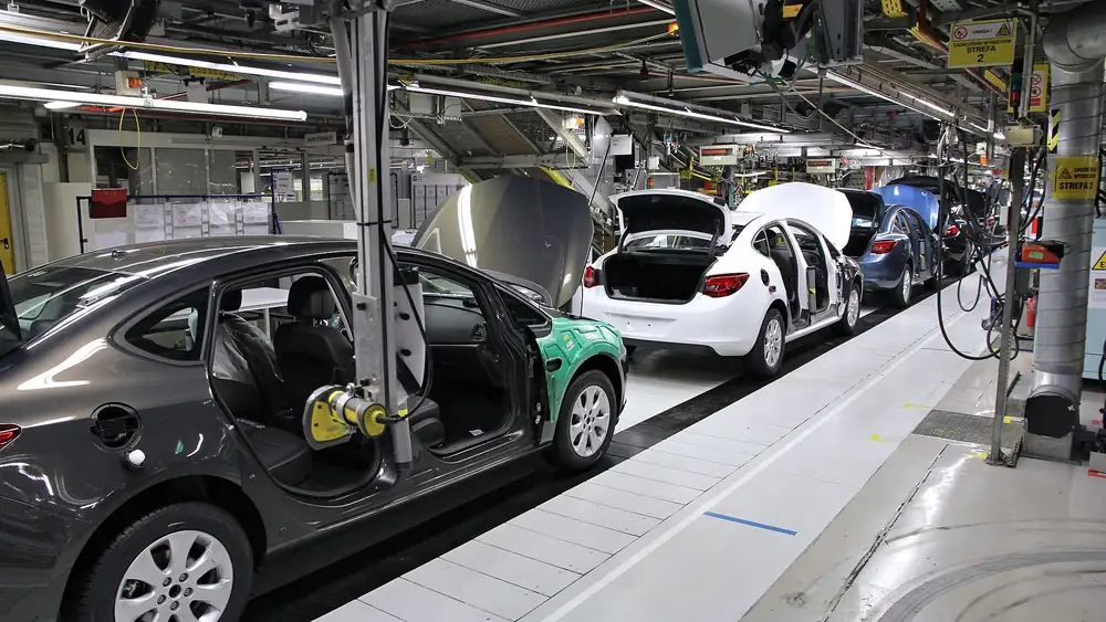 Car bodies moving along an assembly line inside a modern automotive manufacturing plant
